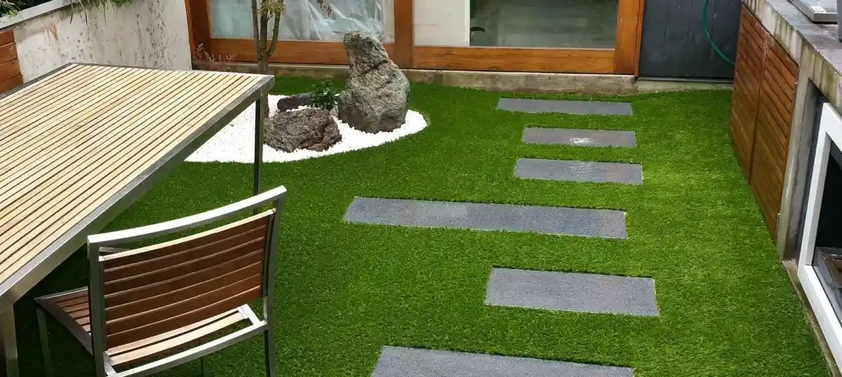 Artificial grass and pavers garden with table and chair. 